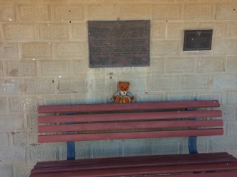 Womble sits on the bench seat in front of the train station