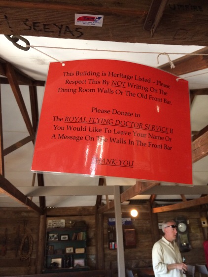 Sign informing people that the next part of the building is Heritage Listed so "Please Respect This By NOT Writing On the Dining Room Walls or the Old Front Bar". People who've written have donated to the Royal Flying Doctor Service first the sign says.