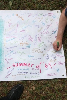 Part of a banner that was once plain white and has been filled with signatures, which surround the words, "summer of '69...."