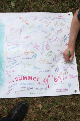 Part of a banner that was once plain white and has been filled with signatures, which surround the words, "summer of '69...."