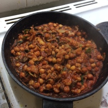 chickpeas and vegetables cooking in the sauce in a deep frying pan